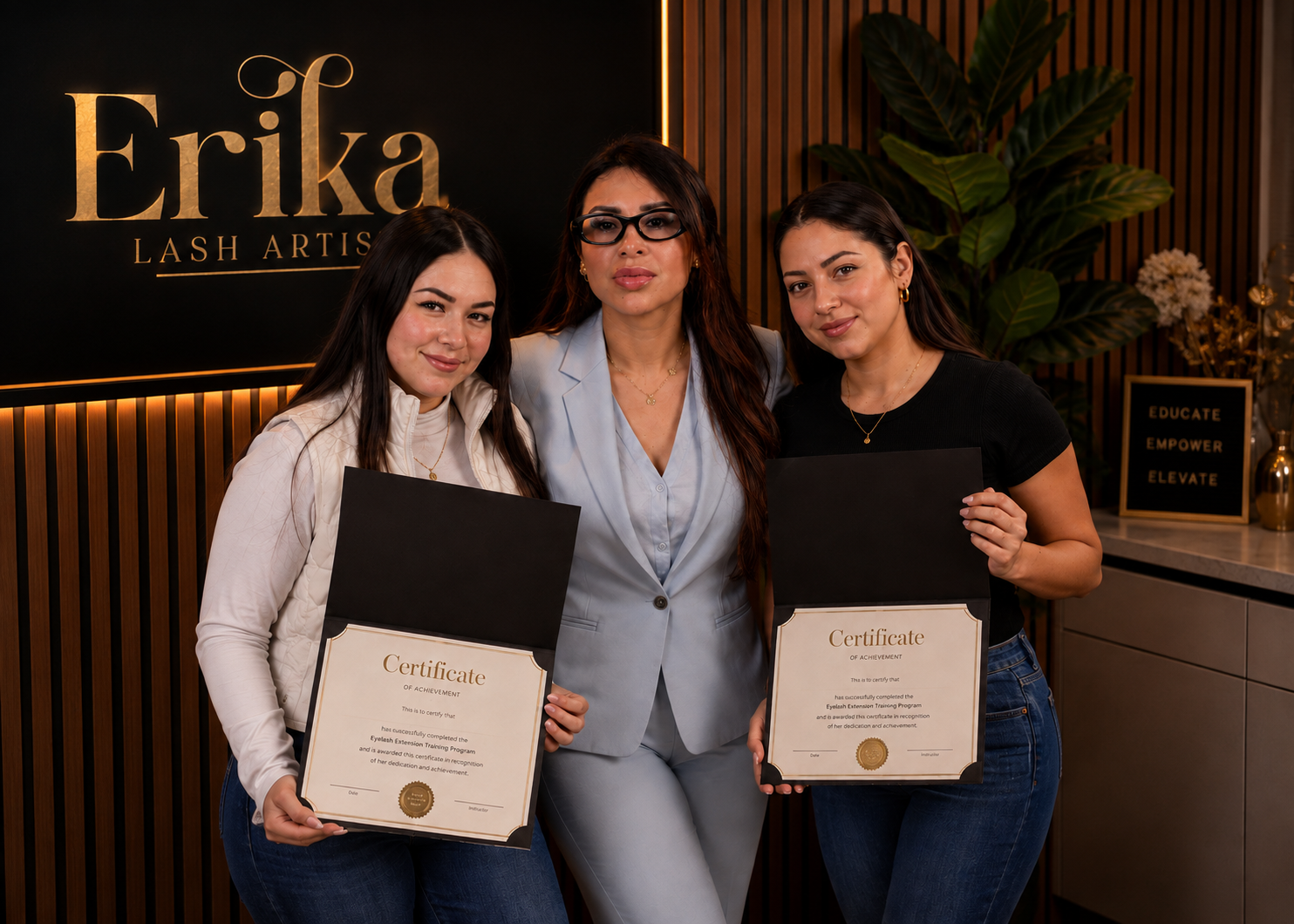 Erika con dos alumnas graduadas sosteniendo sus certificados en la academia